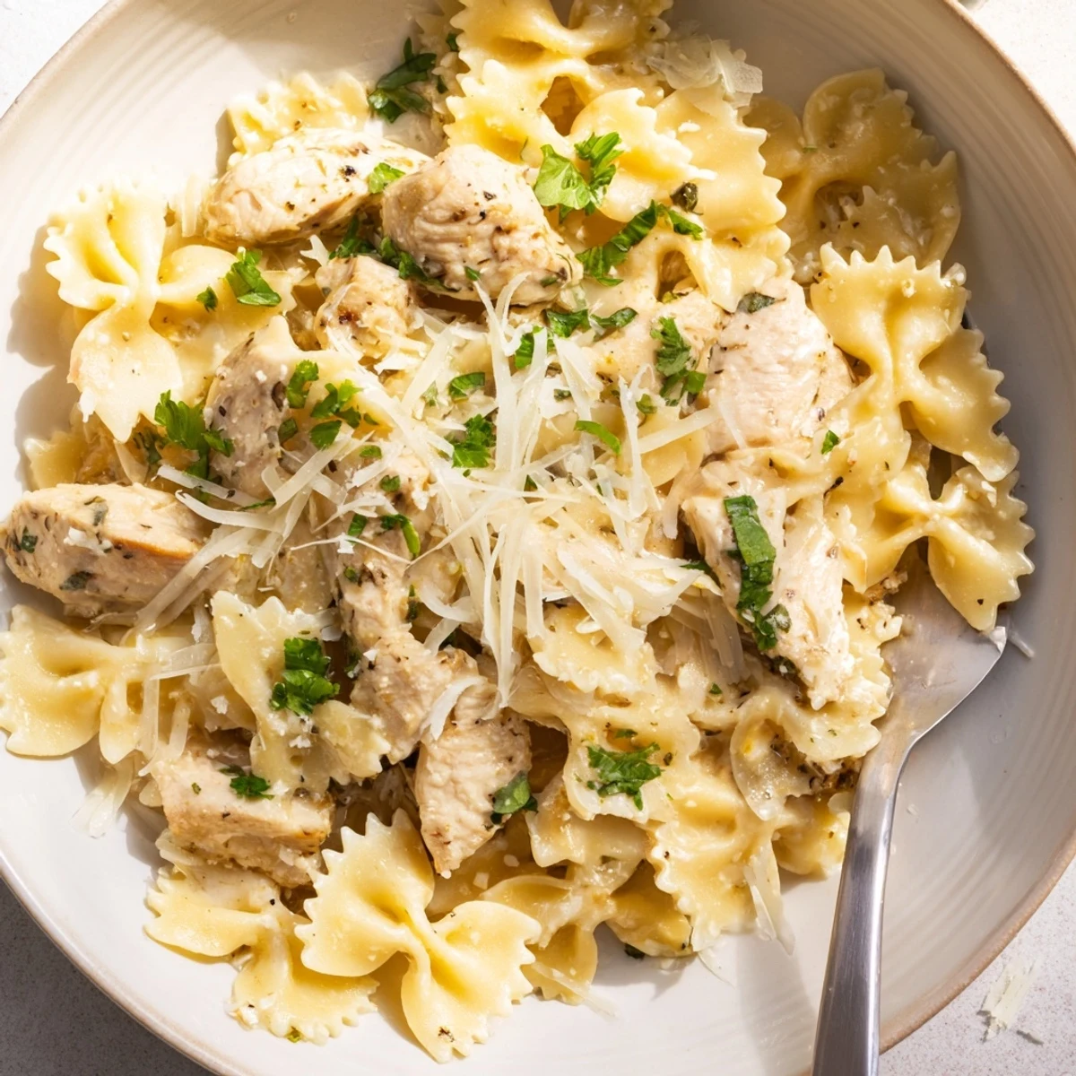 Delicious garlic butter chicken bowties topped with melted mozzarella and fresh herbs.  