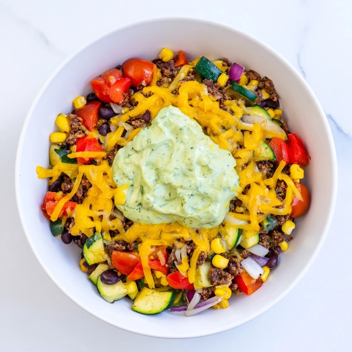 One-pan Veggie-Packed Taco Skillet loaded with vibrant vegetables and avocado yogurt, a delicious meal.