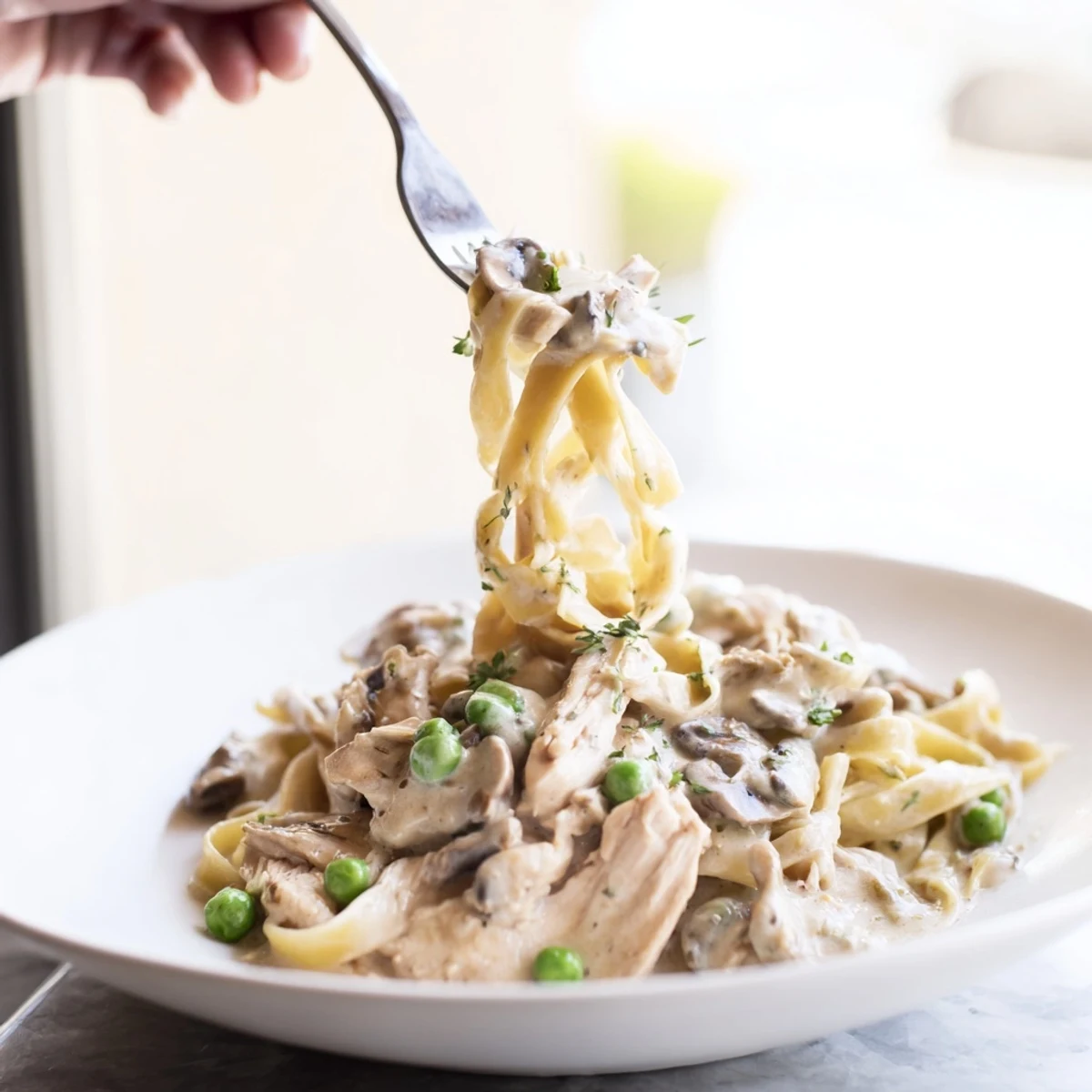 A rich, close-up shot of creamy chicken Alfredo from the slow cooker, garnished with Parmesan cheese and parsley.