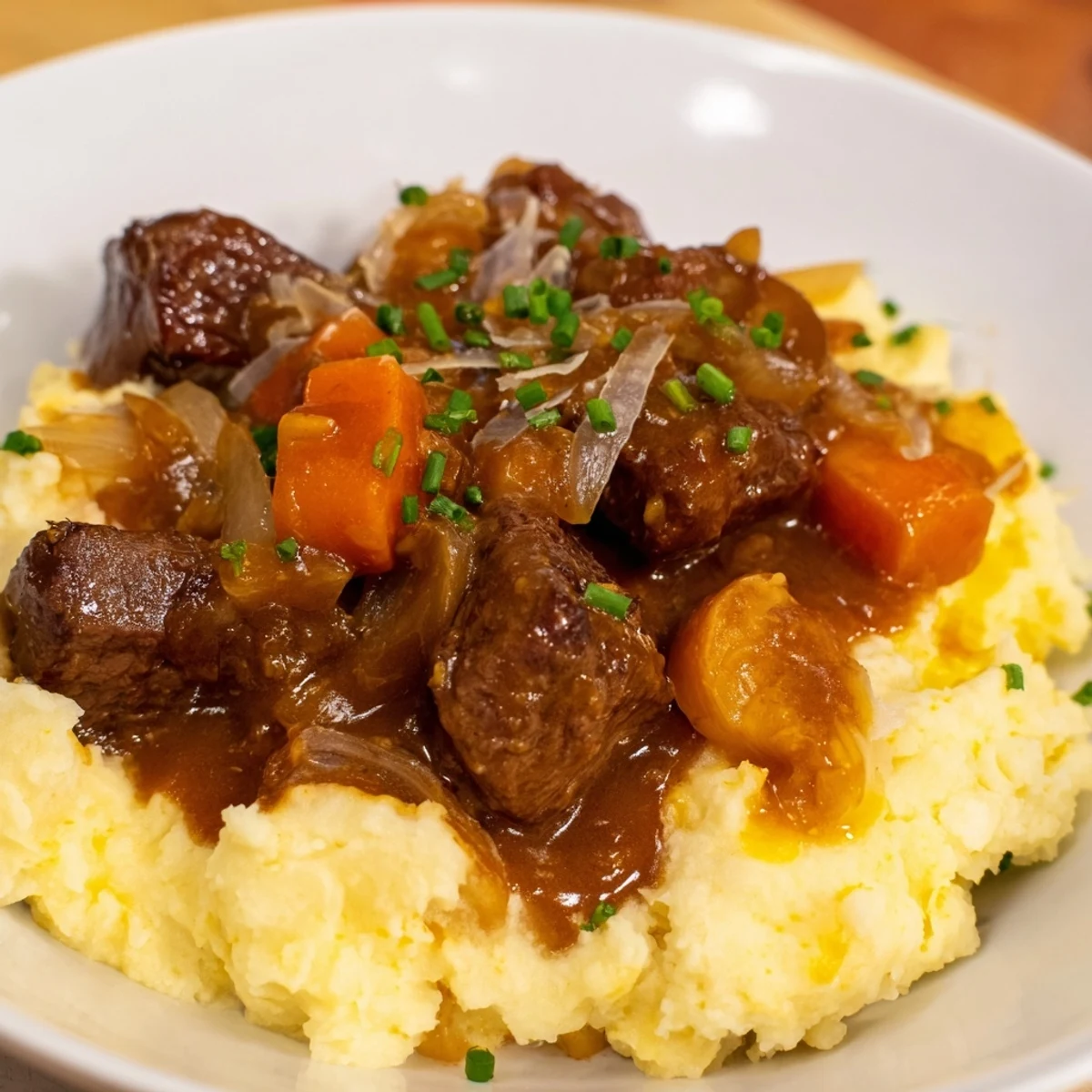 Fall Apple Cider Stew Mash: Tender beef stew over creamy mashed potatoes, garnished with fresh chives.