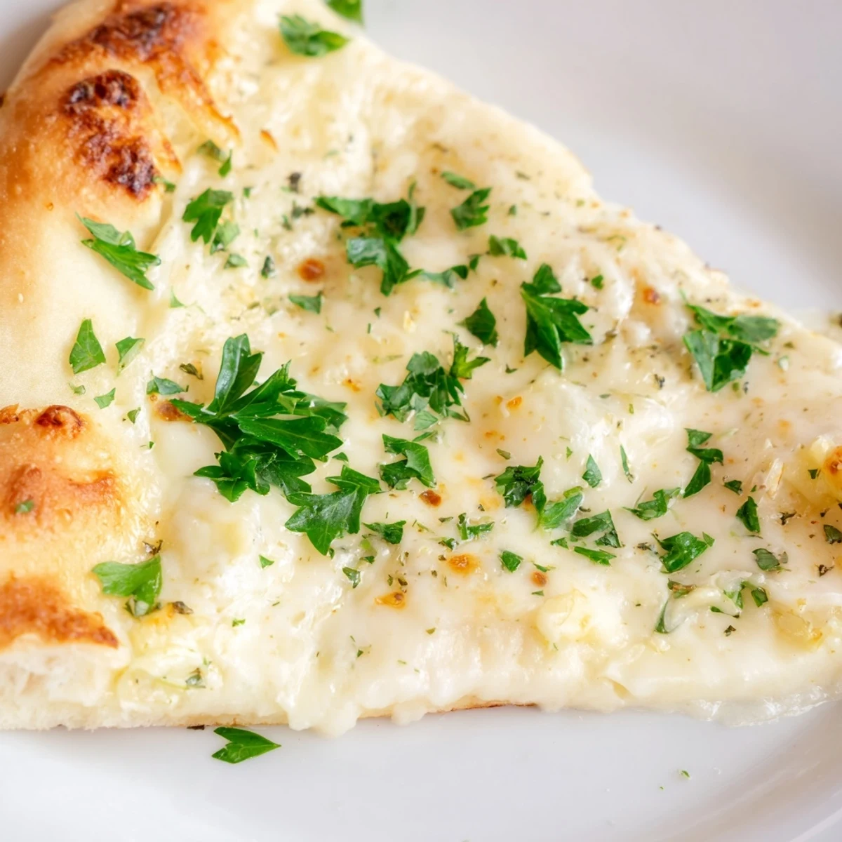 A freshly baked Creamy Garlic White Pizza sits on a wooden board, showcasing golden, bubbly mozzarella and a crisp, brushed crust.