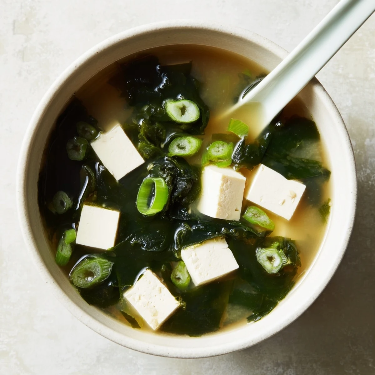 Silky cubes of tofu and tender wakame swimming in a warm, savory Miso Soup With Tofu, garnished with fresh scallions.