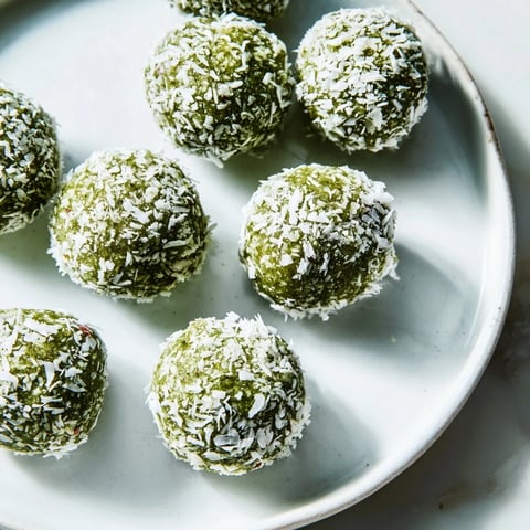 Creamy coconut matcha snowball fat bombs, rolled in shredded coconut, a low-carb keto dessert.