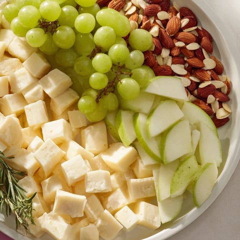 Beautifully arranged Book Club Pairing Platter with various cheeses, meats, fresh fruit and rosemary garnishes.