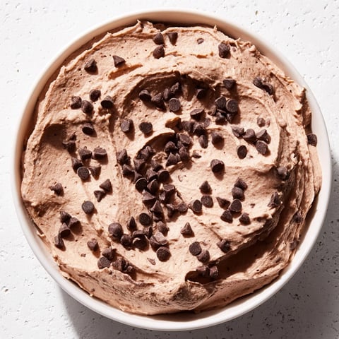 A scoop of creamy gluten-free Brownie Batter Dip, perfect with fresh strawberries and cookies.