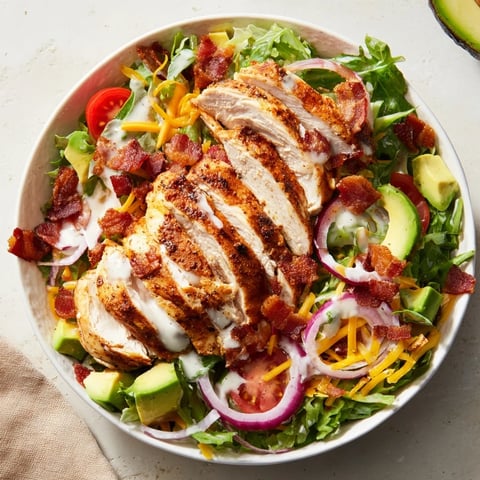 Crispy bacon chicken salad with juicy chicken, crunchy bacon, and fresh greens, ready to eat.