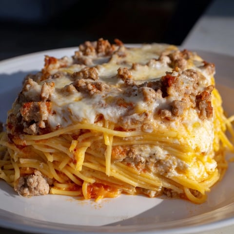 Golden, bubbly Million Dollar Spaghetti, fresh from the oven, with melted cheese and rich meat sauce.