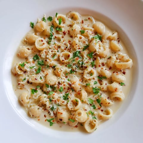 Creamy ditalini pasta boasts a rich garlic sauce, garnished with fresh parsley for a flavorful delight.