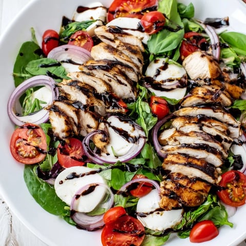 Grilled Caprese Chicken Salad with juicy chicken, ripe tomatoes, and fresh basil, ready to eat.