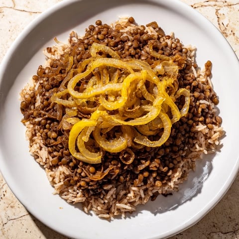 Steaming Lebanese Mjadra, a hearty mix of lentils and rice, is topped with sweet caramelized onions.