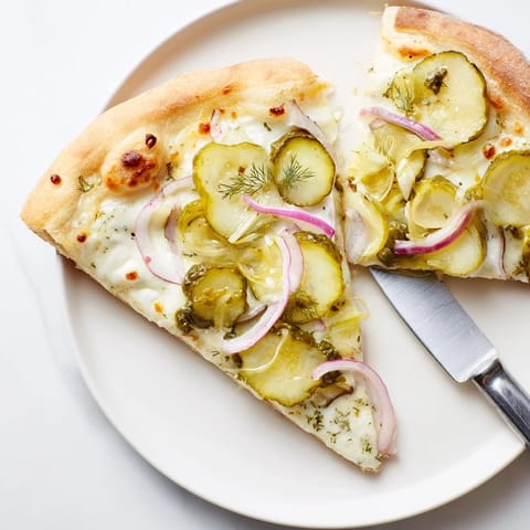 Vibrant Pickle Pizza with rich crème fraîche and crunchy dill for pizza enthusiasts.  