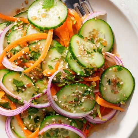 Refreshing cucumber salad remix featuring vibrant veggies and a tangy sesame dressing.  
