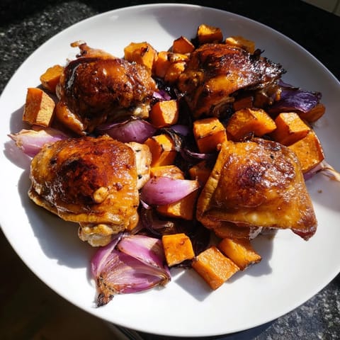 A vibrant close-up showcasing the sweet glaze on the Maple Glazed Chicken & Sweet Potato Bake.