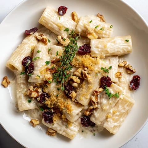 This comforting Cranberry and Brie Tartlet Pasta showcases vibrant red cranberries within a rich, cheesy sauce.