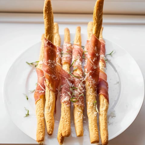 A vibrant close-up of the Golden Gate, savory prosciutto bridging crispy breadsticks, fantastic for parties.