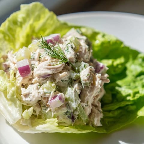Savory shredded chicken mixed with crunchy pickles and herbs, served in chilled lettuce leaves for a light bite.