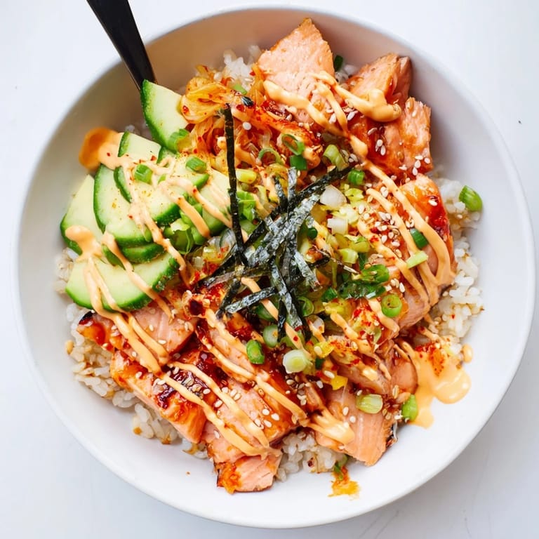 Flavorful crispy salmon rice bowl featuring fluffy rice, kimchi, and crunchy garlic pieces.