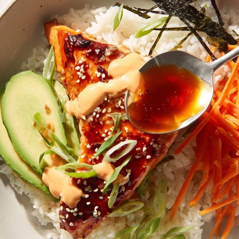This teriyaki salmon rice bowl features tender salmon in a rich glaze with colorful toppings.