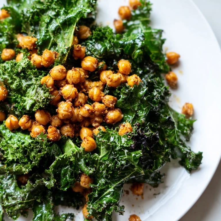 Savor a bite of this delicious Warm Kale Salad with Crispy Chickpeas featuring vibrant greens and roasted chickpeas.